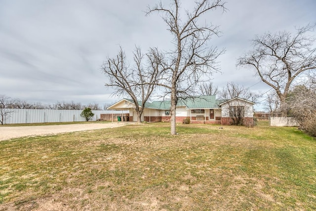 view of yard with an attached carport, fence, and driveway