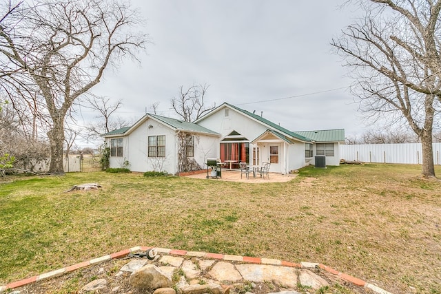 view of front facade featuring a front yard, central AC unit, fence, a patio area, and metal roof