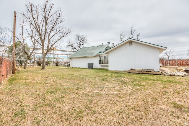 view of yard with central AC and fence