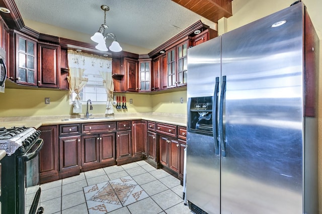 110 N Pope St, San Angelo, TX 76903 - kitchen with stainless steel appliances, dark brown cabinets, light countertops, pendant lighting, and a chandelier