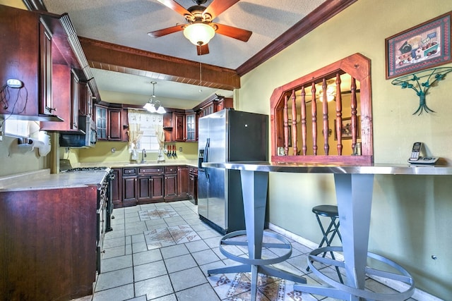 110 N Pope St, San Angelo, TX 76903 - kitchen with stainless steel appliances, light countertops, a ceiling fan, crown molding, and reddish brown cabinets