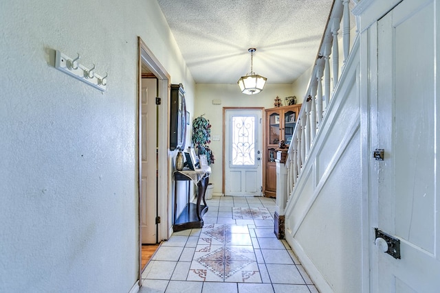 110 N Pope St, San Angelo, TX 76903 - entrance foyer featuring a textured wall, stairs, a textured ceiling, and light tile patterned floors