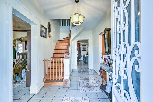 110 N Pope St, San Angelo, TX 76903 - foyer entrance with stairway, light tile patterned floors, a textured ceiling, and arched walkways