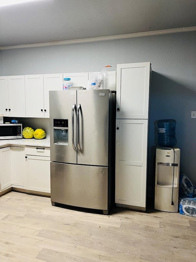 kitchen with white cabinetry, light countertops, light wood finished floors, and stainless steel appliances