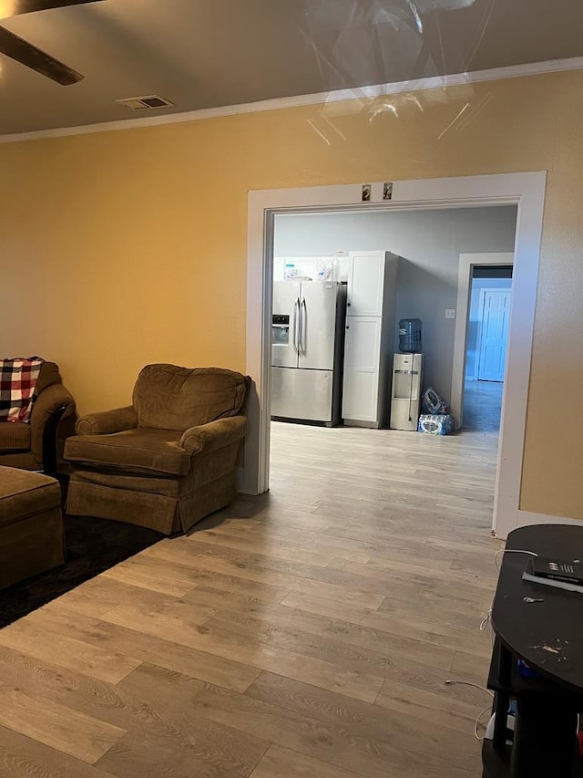 living room featuring crown molding, wood finished floors, and visible vents