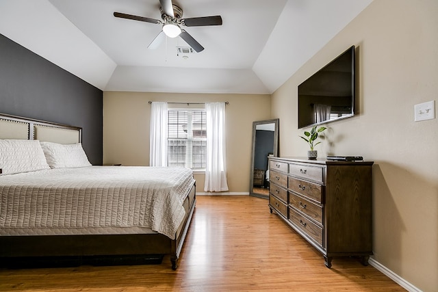 bedroom with vaulted ceiling, ceiling fan, and light hardwood / wood-style floors