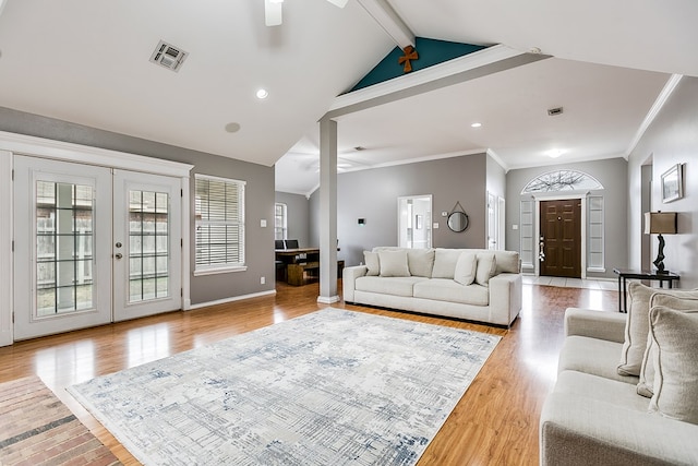 living room featuring french doors, ornamental molding, wood-type flooring, and vaulted ceiling with beams