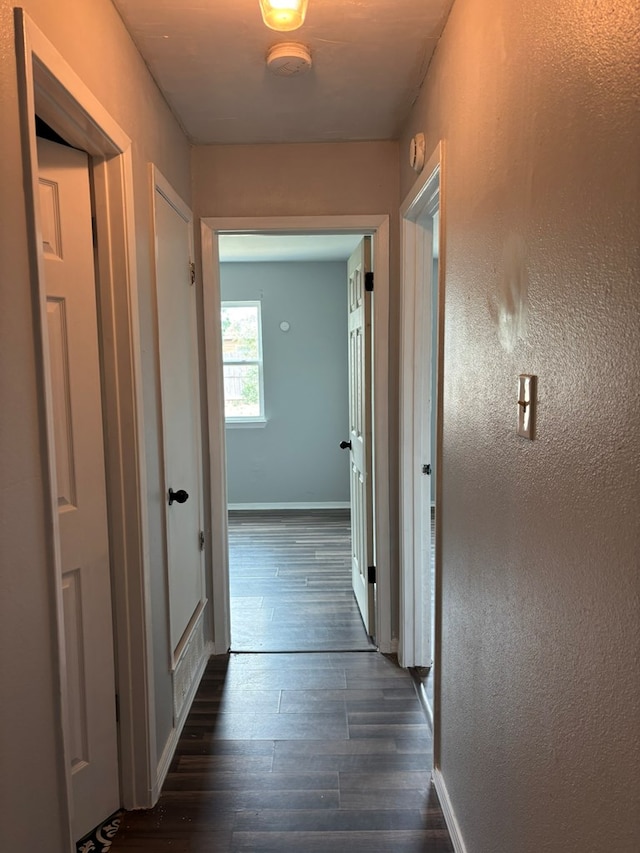 1014 Alpha Cir, San Angelo, TX 76903 - hallway featuring dark wood-type flooring and baseboards