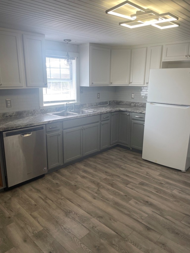 kitchen with sink, white cabinetry, white refrigerator, dark hardwood / wood-style flooring, and dishwasher