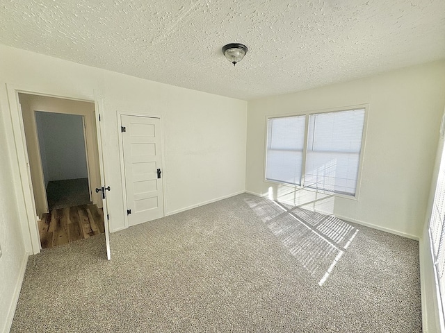 empty room featuring carpet and a textured ceiling