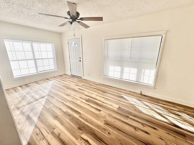 entrance foyer featuring ceiling fan, a textured ceiling, and light wood-type flooring