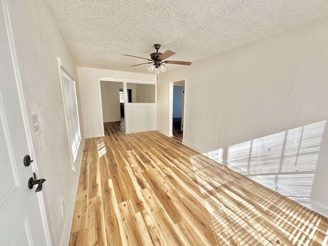 empty room with ceiling fan, a textured ceiling, and light hardwood / wood-style floors