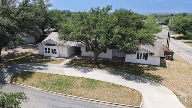 2301 Sul Ross St, San Angelo, TX 76904 - view of front of house with brick siding, driveway, roof with shingles, and a front yard