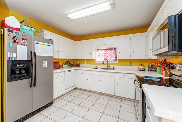 kitchen featuring sink, white cabinetry, stainless steel appliances, light tile patterned flooring, and tile countertops