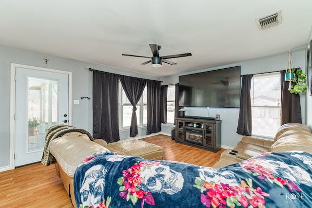 living room with ceiling fan, plenty of natural light, and hardwood / wood-style floors