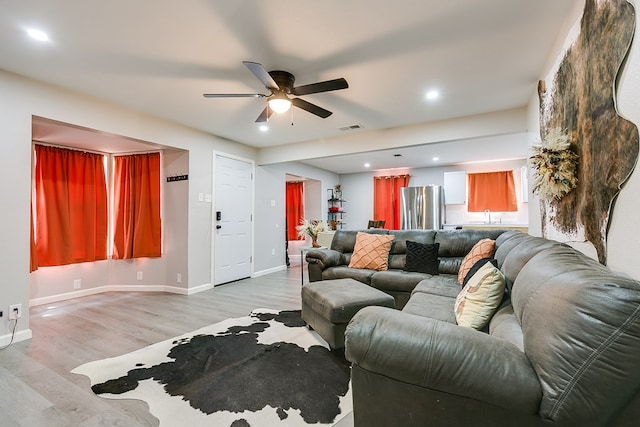 living room with ceiling fan, light wood finished floors, baseboards, visible vents, and recessed lighting