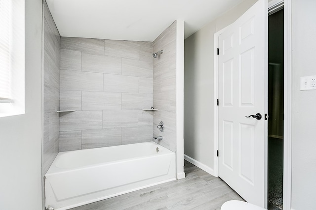 full bathroom featuring baseboards, bathtub / shower combination, and wood finished floors