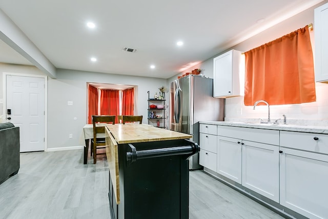 kitchen featuring recessed lighting, light wood finished floors, visible vents, freestanding refrigerator, and white cabinetry