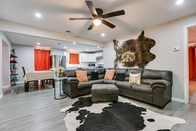 living area featuring recessed lighting, visible vents, a ceiling fan, light wood-style floors, and baseboards
