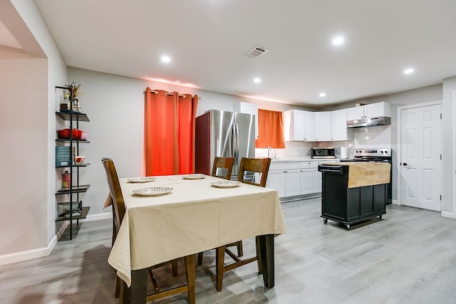 dining area with baseboards, light wood-style floors, visible vents, and recessed lighting