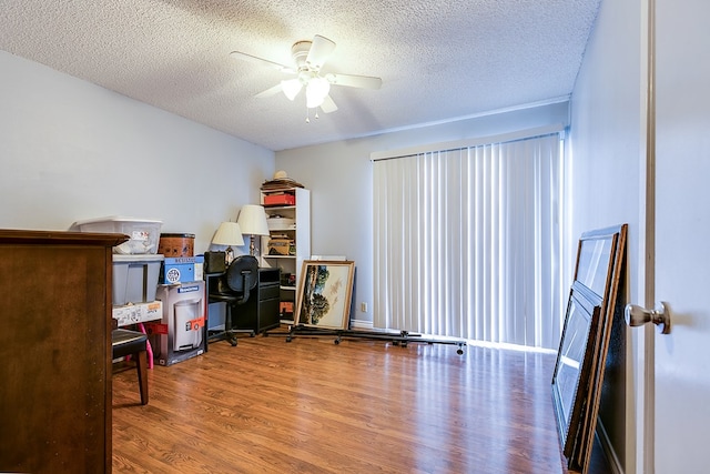 home office with ceiling fan, wood-type flooring, and a textured ceiling