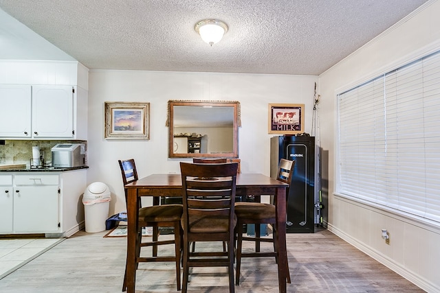 dining room with a textured ceiling and light hardwood / wood-style flooring