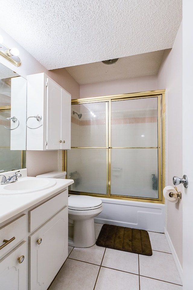 full bathroom featuring vanity, tile patterned flooring, shower / bath combination with glass door, and a textured ceiling