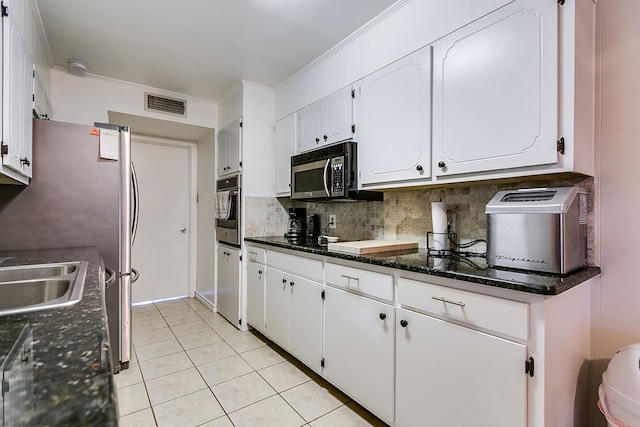 kitchen featuring white cabinetry, light tile patterned floors, decorative backsplash, and stainless steel appliances