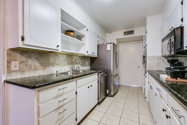 kitchen featuring white cabinetry, sink, backsplash, light tile patterned floors, and stainless steel appliances