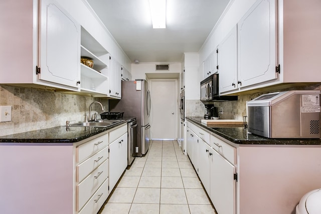 kitchen featuring appliances with stainless steel finishes, white cabinetry, sink, backsplash, and light tile patterned floors