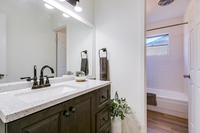 bathroom with vanity, wood finished floors, and tub / shower combination