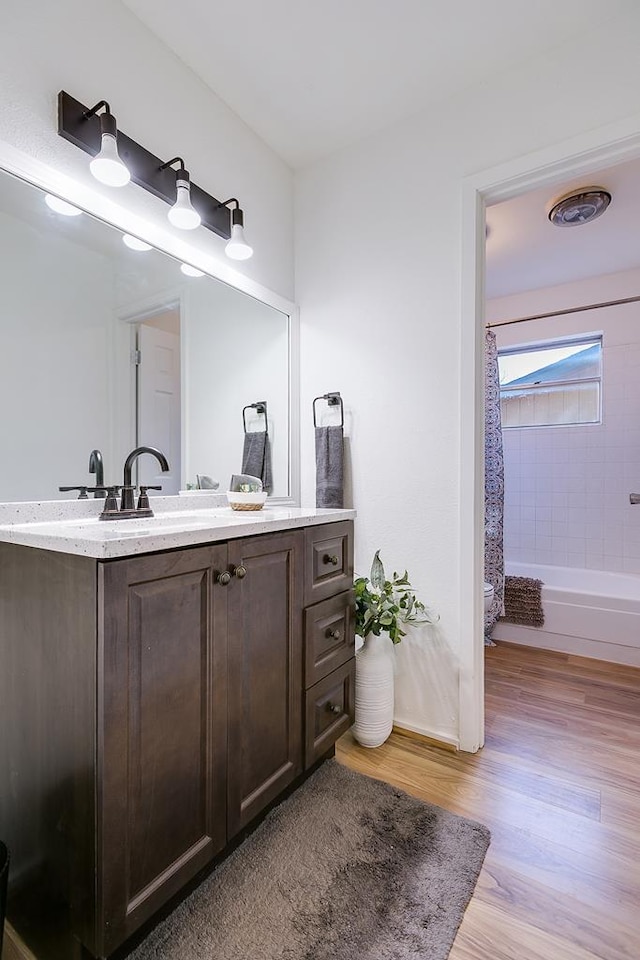 full bath featuring shower / bathtub combination with curtain, wood finished floors, and vanity