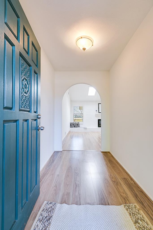 entryway with arched walkways and wood finished floors