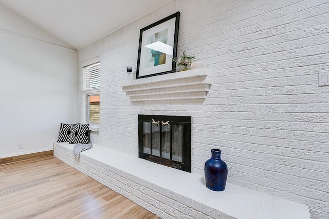 details with a brick fireplace and wood finished floors