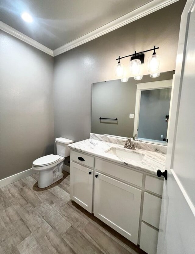 1958 Beaty Rd, San Angelo, TX 76904 - half bath featuring crown molding, wood finished floors, toilet, vanity, and baseboards