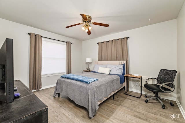 bedroom featuring a ceiling fan, light wood-style floors, and baseboards