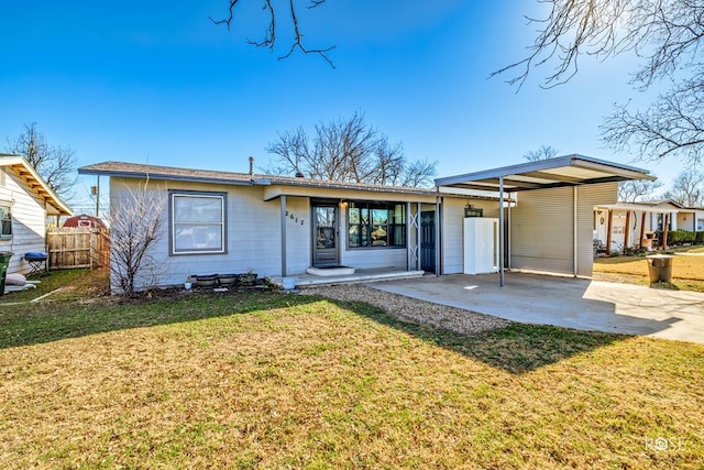 view of front of home featuring concrete driveway, a front lawn, and fence