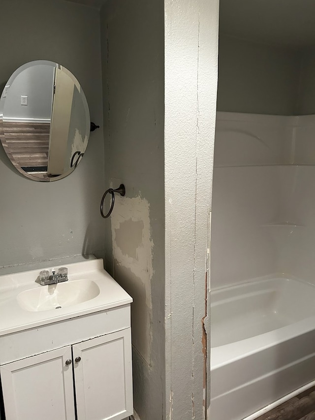 bathroom with vanity and a washtub