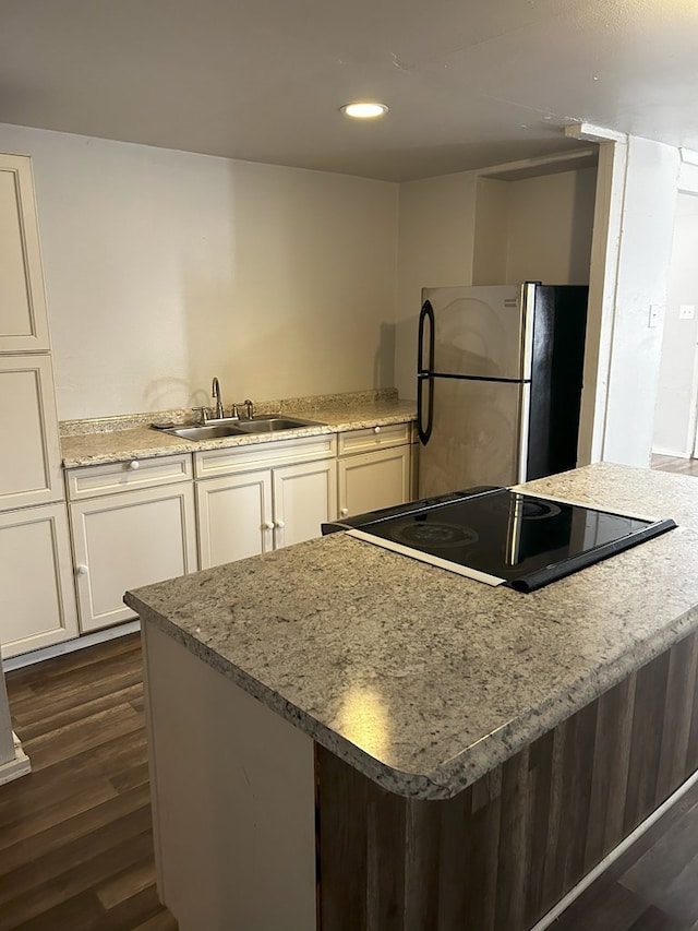 kitchen featuring sink, white cabinets, stainless steel fridge, dark hardwood / wood-style flooring, and range