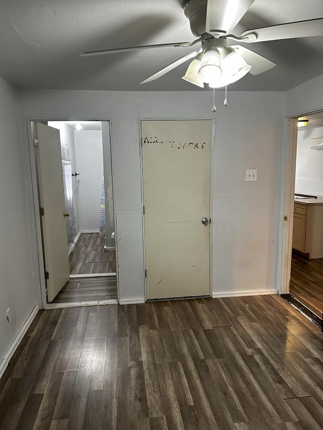 unfurnished bedroom featuring ceiling fan, connected bathroom, and dark hardwood / wood-style flooring