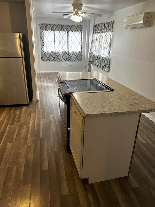 kitchen with electric range, a wall unit AC, stainless steel refrigerator, and a healthy amount of sunlight