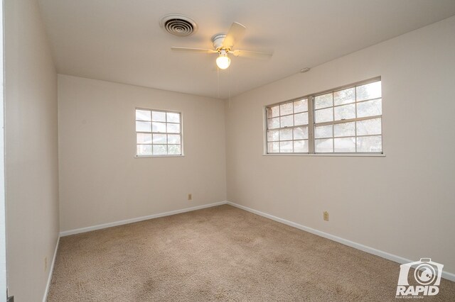 spare room with light colored carpet and ceiling fan