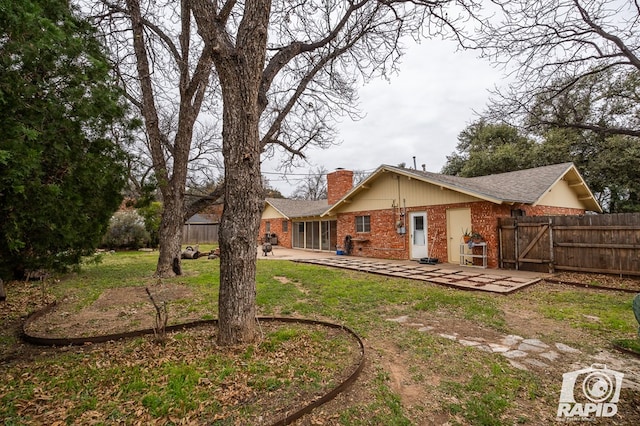 rear view of house featuring a yard and a patio