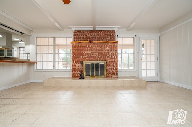 unfurnished living room with a fireplace, tile patterned flooring, and beam ceiling