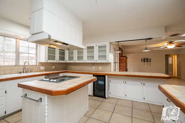 kitchen with white cabinetry, a center island, and tile counters