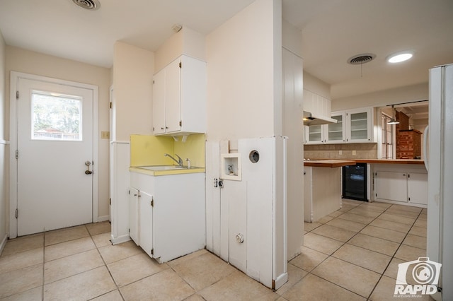 kitchen featuring tasteful backsplash, white refrigerator, wine cooler, and white cabinets