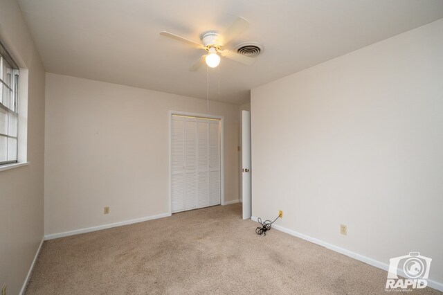 carpeted spare room with ceiling fan