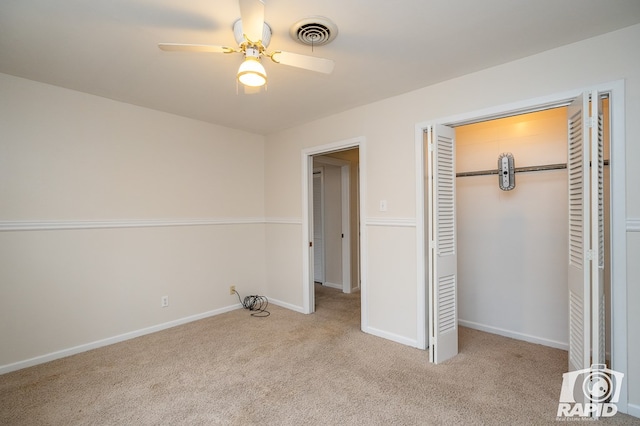 unfurnished bedroom featuring ceiling fan, light colored carpet, and a closet