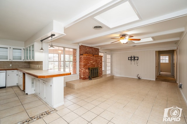 kitchen featuring pendant lighting, white cabinetry, tile counters, light tile patterned floors, and kitchen peninsula