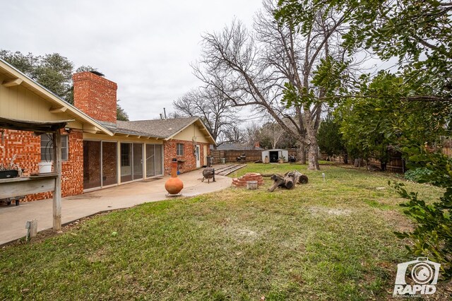 view of yard featuring a shed and a patio